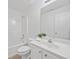 Bright bathroom featuring a vanity with white cabinets and a shower with white tile surround at 554 Grand Ashbury Ln, Sugar Hill, GA 30518