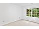 Well-lit bedroom featuring a large window, neutral walls, and plush carpeting at 554 Grand Ashbury Ln, Sugar Hill, GA 30518