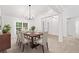 Formal dining room featuring a table set for six, a modern chandelier, and large windows at 554 Grand Ashbury Ln, Sugar Hill, GA 30518