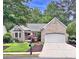 Charming brick home featuring an attached garage, well-manicured lawn, and beautiful landscaping at 554 Grand Ashbury Ln, Sugar Hill, GA 30518