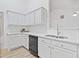 Bright kitchen with white cabinets and quartz countertops with modern sink and stainless steel dishwasher at 554 Grand Ashbury Ln, Sugar Hill, GA 30518