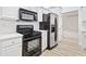 Well-lit kitchen featuring stainless steel appliances, white cabinets, and modern countertops and floor at 554 Grand Ashbury Ln, Sugar Hill, GA 30518