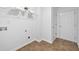 Clean laundry room with shelving, tile floor, and a utility sink connection at 554 Grand Ashbury Ln, Sugar Hill, GA 30518