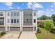 Modern townhome with a mix of white and gray exterior paint, gray brick accents, and a two car garage at 2808 Maddison Towns Ave, Norcross, GA 30071