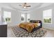 Sun-filled main bedroom featuring tray ceiling, stylish fan, and a contemporary rug at 2808 Maddison Towns Ave, Norcross, GA 30071