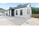 Side view of a charming, white home featuring black trim and a concrete driveway at 3175 Dogwood Dr, Atlanta, GA 30354