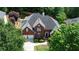 Aerial view of the home featuring a large roof, driveway, and a well-manicured yard at 4046 Creekview Ridge Dr, Buford, GA 30518