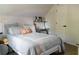 Cozy bedroom with sloped ceilings, plush bedding, and a convenient desk area at 4046 Creekview Ridge Dr, Buford, GA 30518