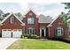 Beautiful red brick home with black shutters, a two-car garage and a well-maintained lawn at 4046 Creekview Ridge Dr, Buford, GA 30518