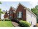 Two-story red brick home with well-manicured landscaping with shrubs and green grass lawn at 4046 Creekview Ridge Dr, Buford, GA 30518
