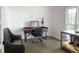 A comfortable home office with a modern desk setup, a leather couch, and a dog crate at 4046 Creekview Ridge Dr, Buford, GA 30518