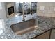 A stainless steel kitchen sink with a modern faucet complements the granite countertops at 4046 Creekview Ridge Dr, Buford, GA 30518