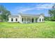 Rear view of home, featuring a covered porch and expansive backyard with plenty of room to relax and entertain at 4824 Se Highway 20, Conyers, GA 30013
