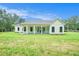 Expansive lawn area showcasing a white modern farmhouse-style home with a covered back porch at 4824 Se Highway 20, Conyers, GA 30013