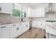 Well-lit kitchen with white cabinets, subway tile backsplash, and stainless steel appliances at 4824 Se Highway 20, Conyers, GA 30013