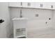 Laundry room features a white utility sink with overhead cabinet storage at 4824 Se Highway 20, Conyers, GA 30013