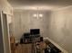 Home gym with exercise bike, weights, shelving, chandelier and flat screen television at 5570 Chemin De Vie, Atlanta, GA 30342