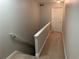 Well-lit hallway with carpet, white railing, and a white door at 5570 Chemin De Vie, Atlanta, GA 30342
