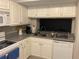 Kitchen with stainless steel sink, gray countertop, and white cabinets at 5570 Chemin De Vie, Atlanta, GA 30342