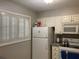 Bright kitchen featuring white appliances, cabinetry, and window shutters at 5570 Chemin De Vie, Atlanta, GA 30342