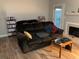 Comfortable living room with a dark brown couch, hardwood floors, and a fireplace at 5570 Chemin De Vie, Atlanta, GA 30342