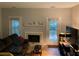 Comfortable living room with wood floors, fireplace, sofa, and access to the yard at 5570 Chemin De Vie, Atlanta, GA 30342