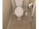 Compact toilet area featuring neutral tile flooring and white toilet at 5570 Chemin De Vie, Atlanta, GA 30342