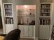 Charming wet bar with custom cabinets, sink, and shelving for glassware and media at 5570 Chemin De Vie, Atlanta, GA 30342