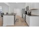 Kitchen features stainless steel appliances, white cabinets, and a breakfast bar with modern countertops at 180 Eryn Ter, Covington, GA 30014