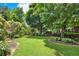 Green backyard with mature trees, landscaping and well-maintained lawn at 230 Channings Lake Dr, Lawrenceville, GA 30043