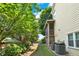 Side yard of the property showing lush landscaping, air conditioning units, and the back deck at 230 Channings Lake Dr, Lawrenceville, GA 30043