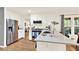 Bright, open kitchen featuring white cabinets, stainless appliances, and a breakfast bar with hardwood floors at 230 Channings Lake Dr, Lawrenceville, GA 30043