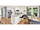 Bright eat-in kitchen features white cabinets, a center island, stainless appliances, and hardwood floors at 230 Channings Lake Dr, Lawrenceville, GA 30043