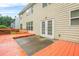 Backyard featuring a two story house with white framed window, a painted deck, and green bushes at 606 Hay Meadow, Acworth, GA 30102