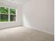 A bedroom with plush carpet, a bright window, and neutral decor at 606 Hay Meadow, Acworth, GA 30102