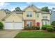 Charming two-story home featuring a red door, manicured lawn and a two car garage at 606 Hay Meadow, Acworth, GA 30102