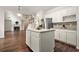 Open floor plan featuring island with white cabinets in kitchen, flowing into living room with fireplace and staircase at 606 Hay Meadow, Acworth, GA 30102