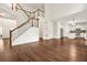 Open-concept living area with hardwood floors, stairs, and view of the kitchen with stainless steel appliances at 606 Hay Meadow, Acworth, GA 30102