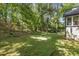 Expansive backyard featuring a lush green lawn, mature trees, and a view of the house at 965 Heards Ferry Rd, Sandy Springs, GA 30328