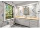This bathroom offers a marble countertop and a window that brings in ample natural light at 965 Heards Ferry Rd, Sandy Springs, GA 30328