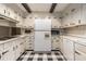 This kitchen features tiled floor, white cabinetry and countertops, and modern appliances at 965 Heards Ferry Rd, Sandy Springs, GA 30328