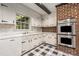 This kitchen features tiled floor, white cabinetry and countertops, and stainless-steel oven at 965 Heards Ferry Rd, Sandy Springs, GA 30328