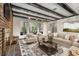 Inviting living room featuring exposed beam ceilings, fireplace, and a seamless view into the sunroom at 965 Heards Ferry Rd, Sandy Springs, GA 30328
