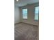 A carpeted bedroom featuring two windows that offer natural light at 1001 Limburg Dr, Hampton, GA 30228