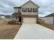 Two-story home featuring a two-car garage and a mix of brick and siding on the facade at 1001 Limburg Dr, Hampton, GA 30228