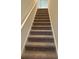 A carpeted staircase with a white handrail leading to the upper level of the home at 1001 Limburg Dr, Hampton, GA 30228