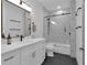 A modern bathroom featuring a vanity, black fixtures, and a shower-tub with geometric patterned tile at 208 Wade Creek Rd, Alpharetta, GA 30009