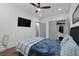 A cozy bedroom features a ceiling fan, a wall-mounted TV, and a comfortable bed with stylish bedding at 208 Wade Creek Rd, Alpharetta, GA 30009