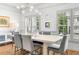 Bright dining room with modern light fixture, plantation shutters, hardwood floors and seating for six at 208 Wade Creek Rd, Alpharetta, GA 30009