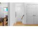 Hallway featuring hardwood floors, modern light fixture, white doors, and a glimpse into an adjacent bedroom at 208 Wade Creek Rd, Alpharetta, GA 30009